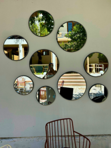 Multiple different sized mirrors grouped on one wall
